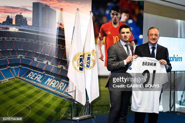 Former Manchester City's Spanish midfielder Brahim Diaz holds his new jersey with Real Madrid's president Florentino Perez during his oficial...