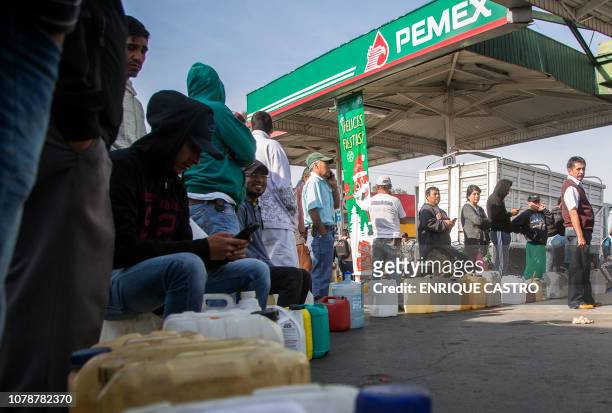 People queue to buy gasoline at a station in Morelia, Michoacan State, on January 7, 2019 as shortages have also been reported in several other...