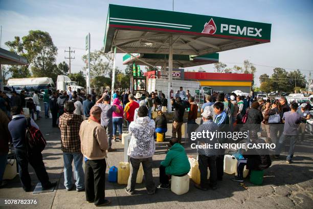 People queue to buy gasoline at a station in Morelia, Michoacan State, on January 7, 2019 as shortages have also been reported in several other...