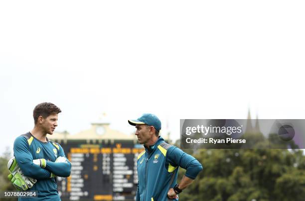 Tim Paine of Australia speaks with Justin Langer, coach of Australia, during day three of the First Test match in the series between Australia and...