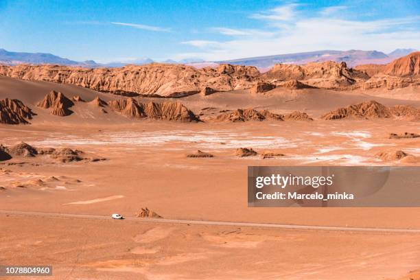vehículo en la distancia cruzando el desierto de atacama. - región de atacama fotografías e imágenes de stock