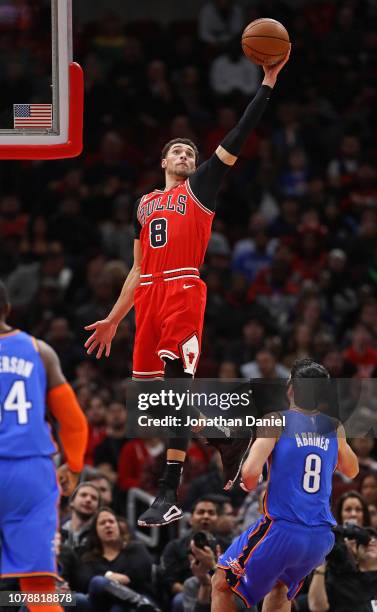 Zach LaVine of the Chicago Bulls leaps high over Alex Abrines of the Oklahoma City Thunder to catch a pass at the United Center on December 07, 2018...