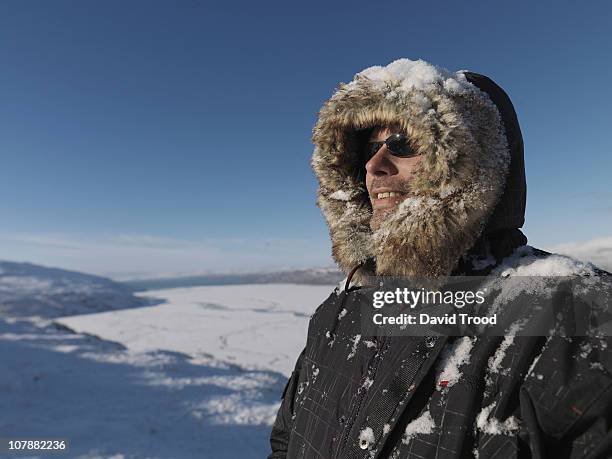 man standing in the snow in greenland - parka coat stockfoto's en -beelden