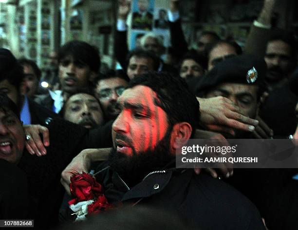 Arrested Pakistani bodyguard Malik Mumtaz Hussain Qadri wearing a garland leaves the court in Islamabad on January 5, 2011 a day after the...