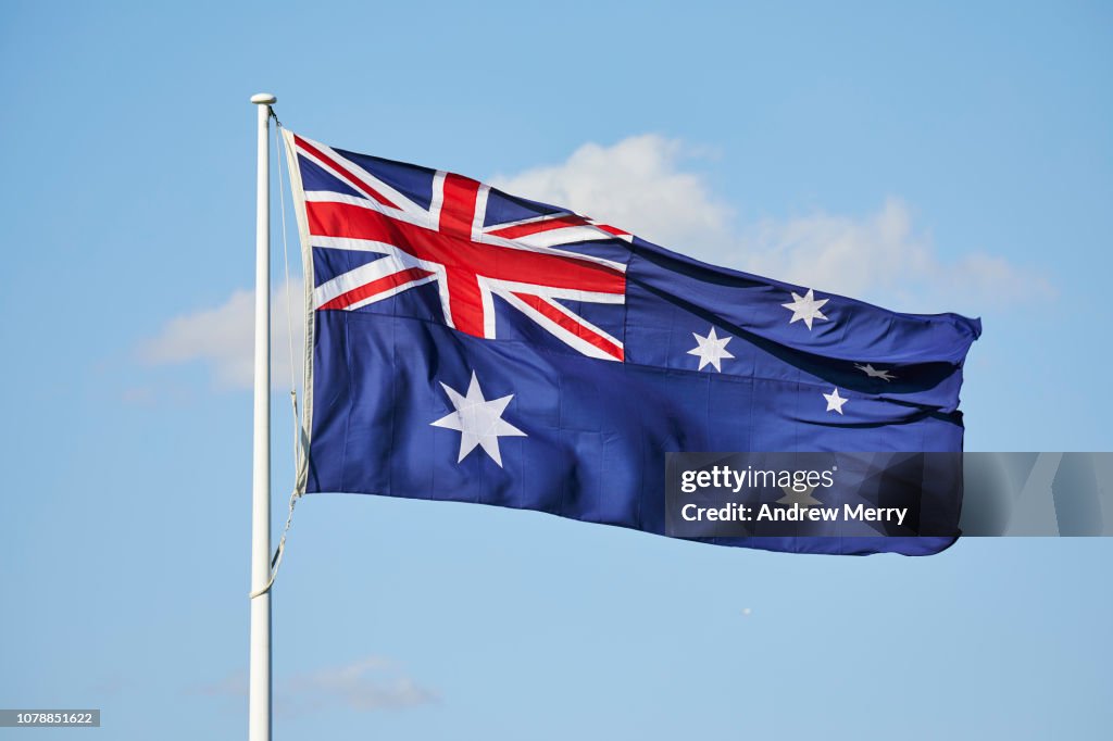 Australian Flag flying in the wind with blue sky