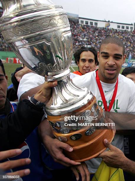 Brazil's forward and striker Adriano Ribeiro holds the Copa America 2004 trophy, 25 July 2004, after defeating Argentina in the final match at the...