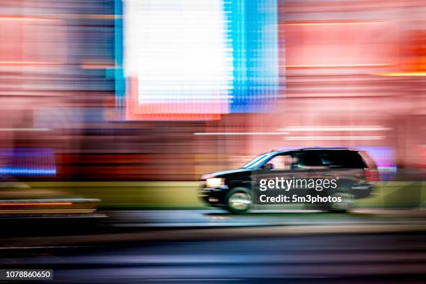car motion blur on city street at night - suv stock-fotos und bilder