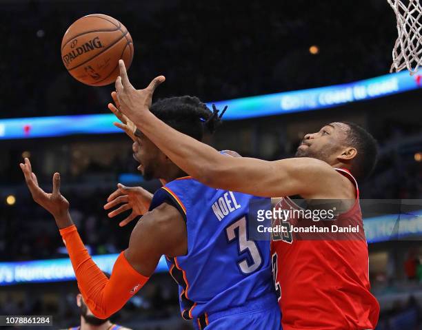 Jabari Parker of the Chicago Bulls battles for a rebound with Nerlens Noel of the Oklahoma City Thunder at the United Center on December 07, 2018 in...