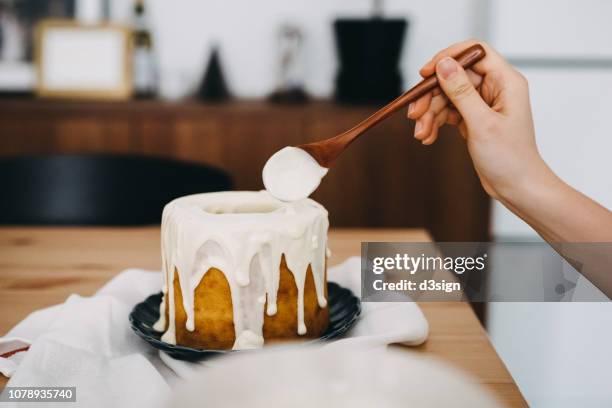 woman's hand decorating cake with white chocolate - food decoration stock-fotos und bilder