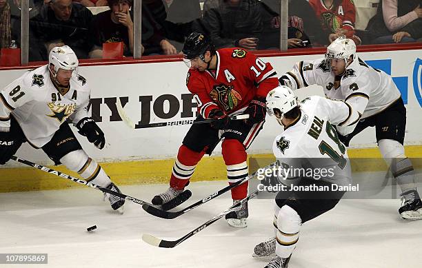 Patrick Sharp of the Chicago Blackhawks tries to pass the puck surrounded by Brad Richards, James Neal and Stephane Robidas of the Dallas Stars at...