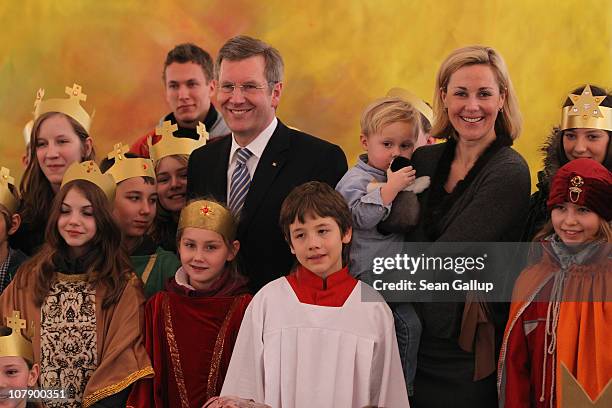 German President Christian Wulff and his wife Bettina, who is holding their son Linus pose with child Epiphany carolers at Bellevue Presidential...