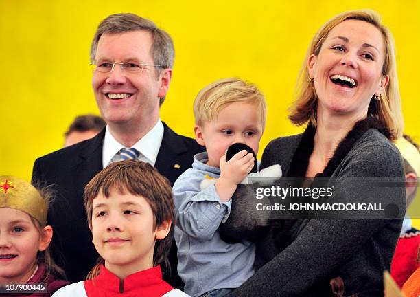 German President Christian Wulff , his wife Bettina Wulff and their two-year-old son Linus pose with Carol singers from the Hamburg area during a...