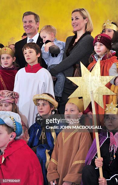 German President Christian Wulff , his wife Bettina Wulff and their two-year-old son Linus pose with Carol singers from the Hamburg area during a...