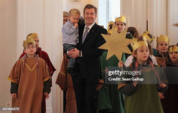 German President Christian Wulff, who is holding his son Linus receives child Epiphany carolers at Bellevue Presidential Palace on January 6, 2011 in...