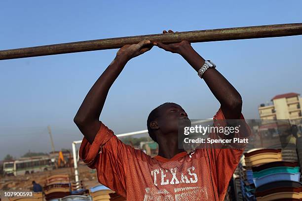 Teenager works on the construction of a tent which is to be used for the referendum vote in the southern Sudanese city of Juba January 6, 2011 in...