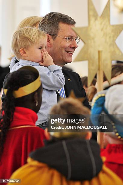 German President Christian Wulff , his wife Bettina and their two-year-old son Linus speak with Carol singers from the Hamburg area during a...