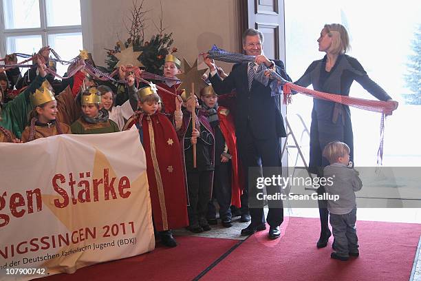 German President Christian Wulff and his wife Bettina, accompanied by their son Linus receive child Epiphany carolers at Bellevue Presidential Palace...