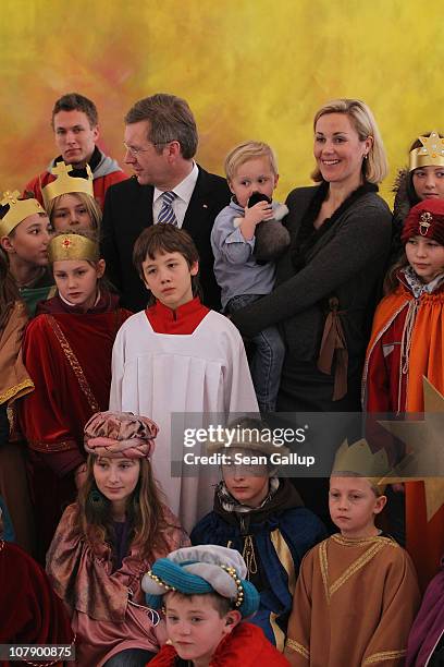 German President Christian Wulff and his wife Bettina, who is holding their son Linus pose with child Epiphany carolers at Bellevue Presidential...