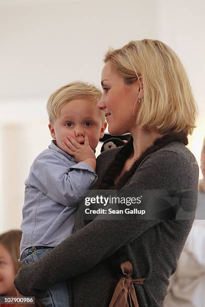 German First Lady Bettina Wulff carries her son Linus at a reception for child Epiphany carolers at Bellevue Presidential Palace on January 6, 2011...