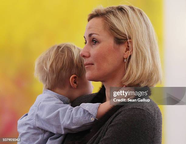 German First Lady Bettina Wulff carries her son Linus at a reception for child Epiphany carolers at Bellevue Presidential Palace on January 6, 2011...