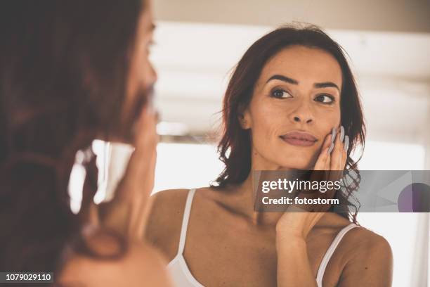 woman doing skin care routine at home - cream for face stock pictures, royalty-free photos & images