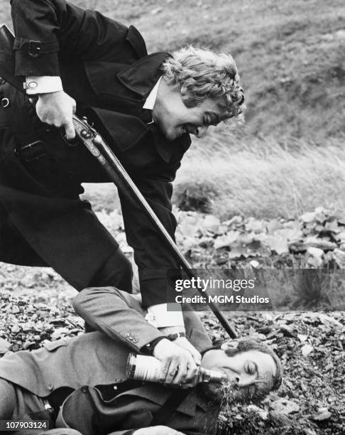 English actor Michael Caine as Jack Carter and Ian Hendry as Eric Paice in Mike Hodges' thriller 'Get Carter', 1970. Carter forces Paice to drink a...