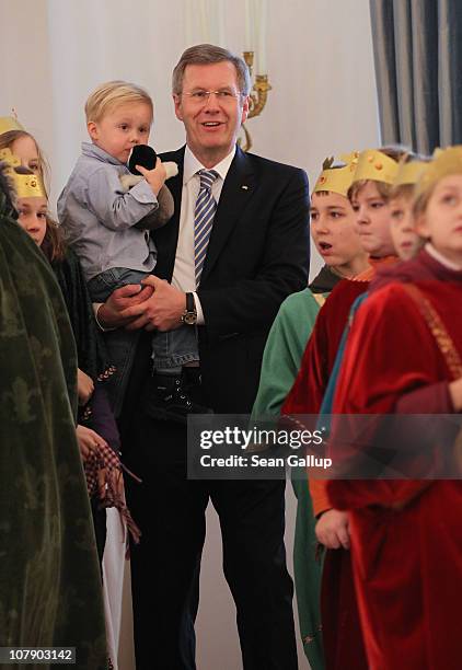 German President Christian Wulff, who is holding his son Linus receives child Epiphany carolers at Bellevue Presidential Palace on January 6, 2011 in...