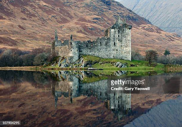 castle reflected in a loch - scottish culture fotografías e imágenes de stock