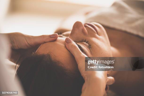 femme recevant un massage du visage au spa - réflexologie photos et images de collection