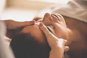 Woman receiving facial massage at spa