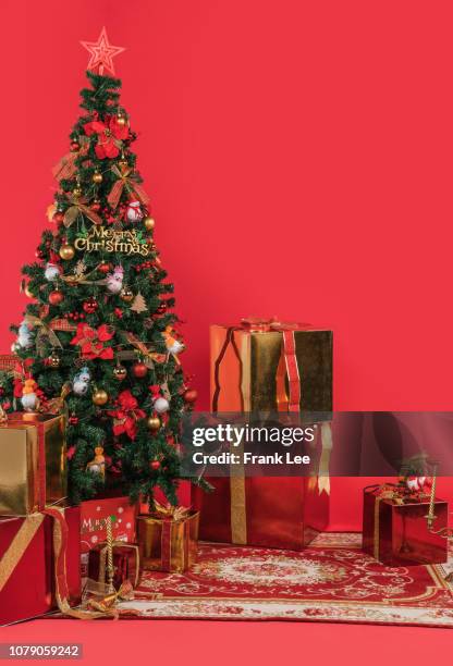 christmas. glowing tree. red background. gifts and decorations. - row of christmas trees stock pictures, royalty-free photos & images