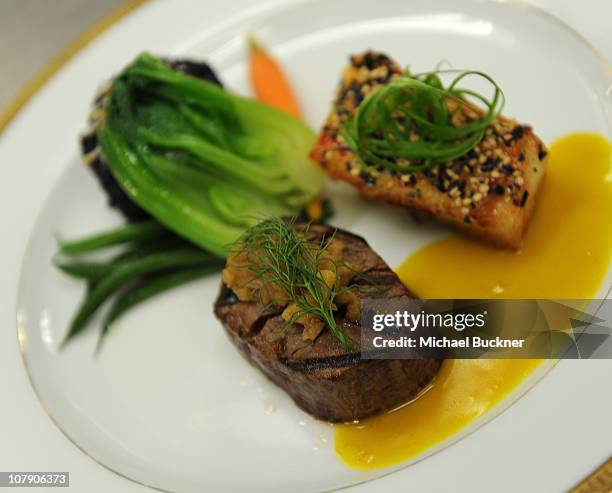 View of the entree featuring grilled beef tenderloin with caramelized fennel marmalada and sauteed mild chili sesame crusted filet of sea bass is...