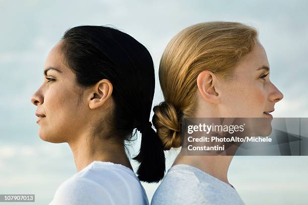 women back to back, portrait - gegensatz stock-fotos und bilder