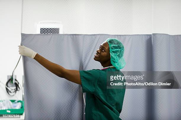 nurse closing privacy curtain in hospital room - hospital curtain stock pictures, royalty-free photos & images