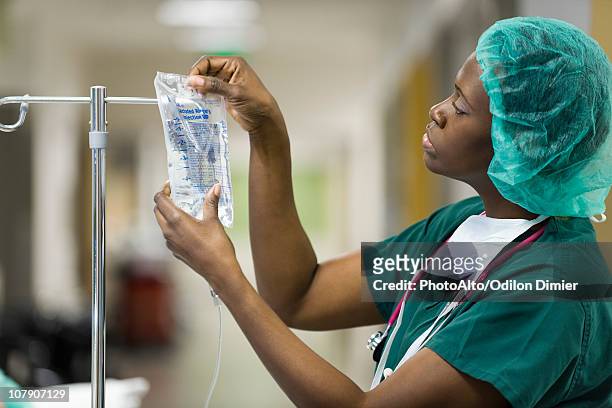 nurse preparing iv drip - flebo salina foto e immagini stock