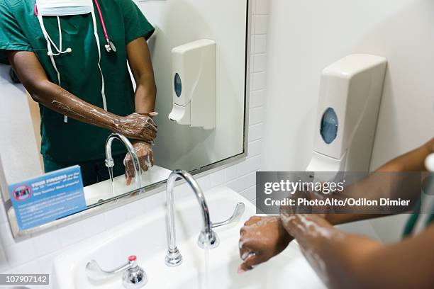 healthcare worker washing hands - doctor scrubs stock pictures, royalty-free photos & images