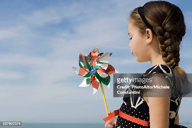 little girl blowing pinwheel - 紙風車 ストックフォトと画像