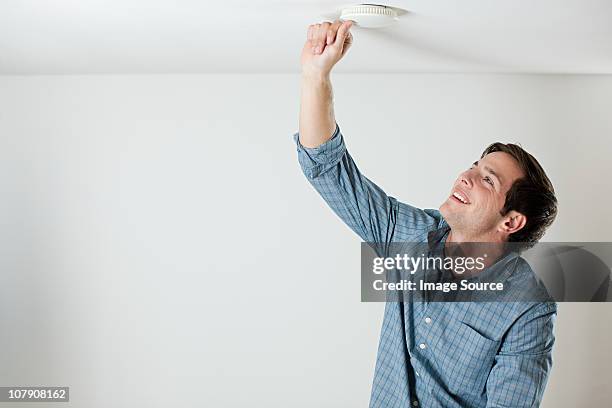 joven las pruebas de límite de alarma de humo - detector de humo fotografías e imágenes de stock