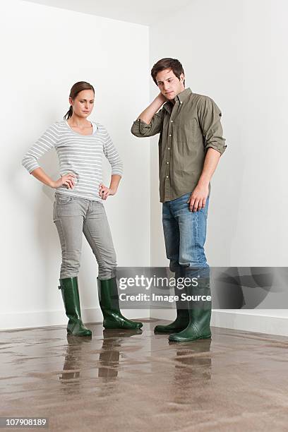 young couple on flooded floor - couple standing stockfoto's en -beelden