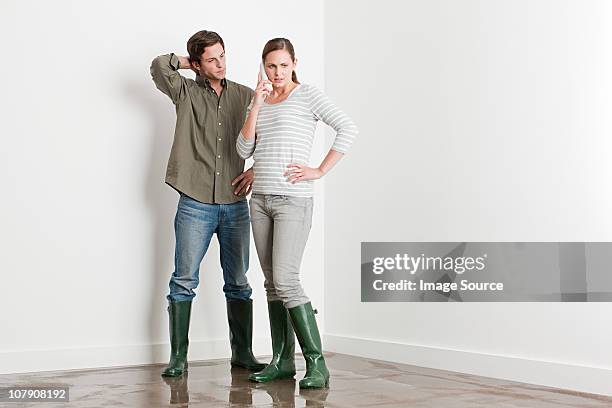 young couple on flooded floor - flooded home stock pictures, royalty-free photos & images