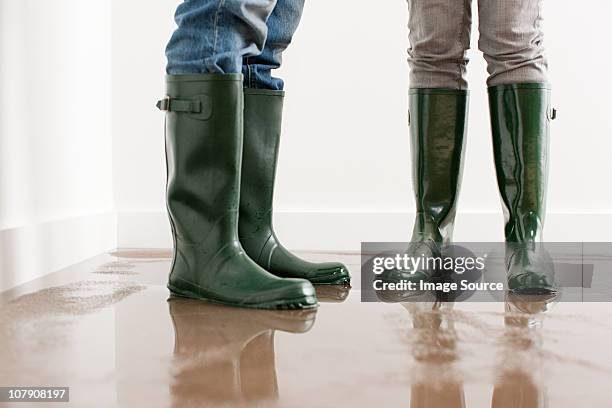 pareja joven en wellington botas en entra piso - inundación fotografías e imágenes de stock
