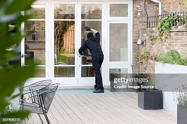 ladrón de casas parado en la puerta del patio - thief fotografías e imágenes de stock