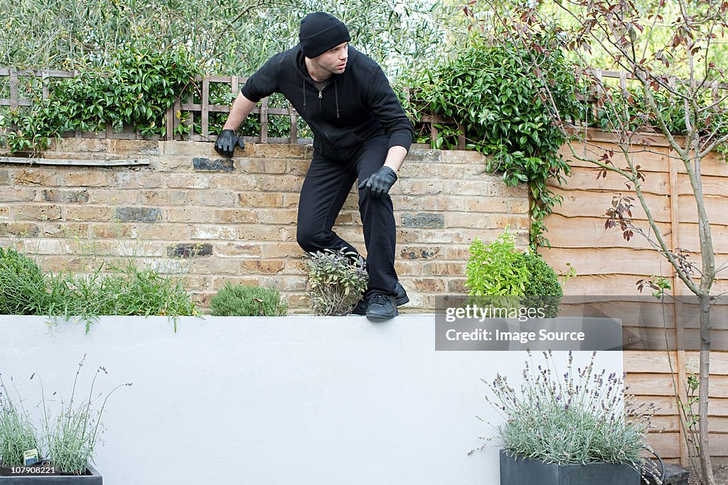 Burglar climbing on wall