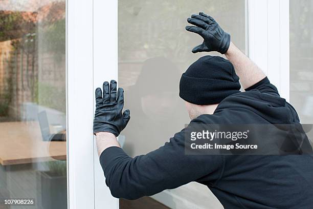 burglar looking through window - thief stock pictures, royalty-free photos & images