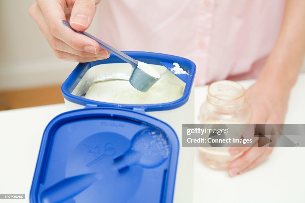 Close up of mother preparing baby formula