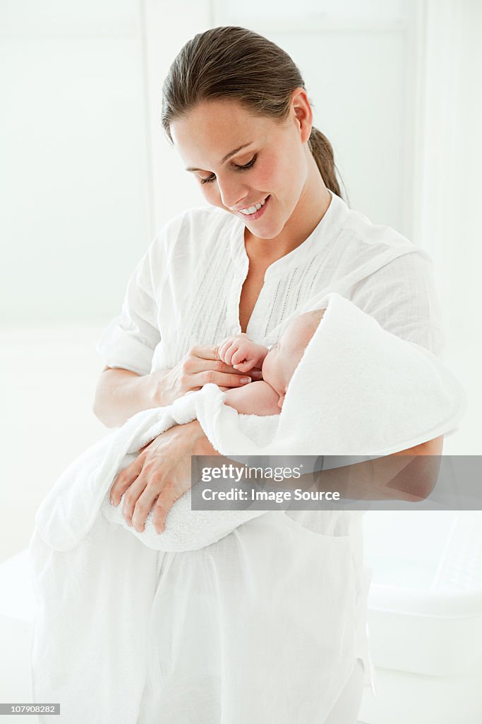 Mother and baby son wrapped in towel