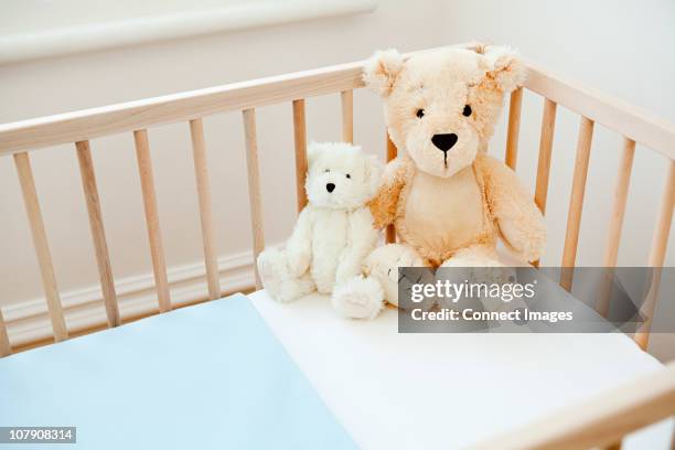 teddy bears on crib - cot stock pictures, royalty-free photos & images