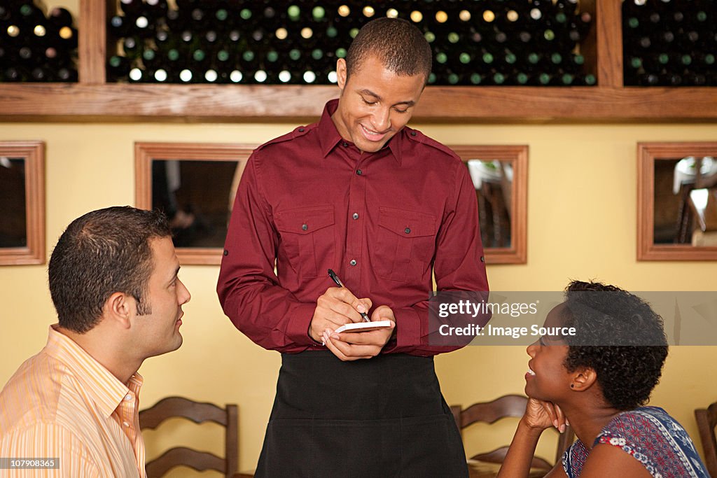 Empregado de Mesa com encomendas de clientes em restaurante