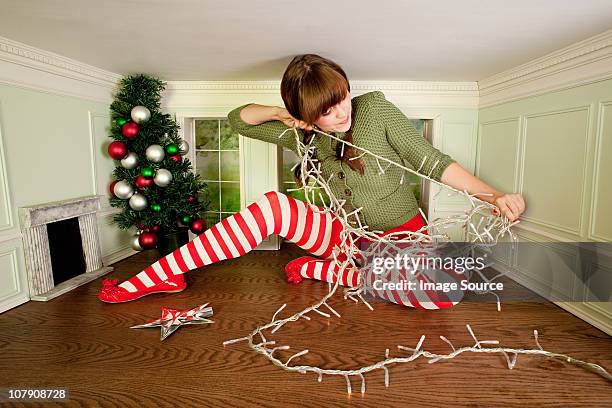 young woman in small room with christmas lights - offbeat stock pictures, royalty-free photos & images