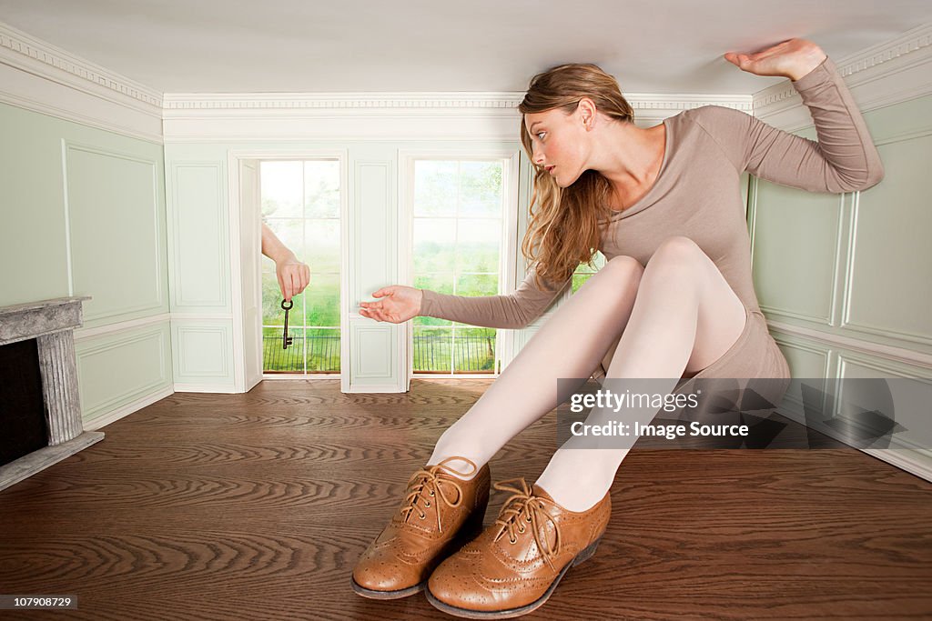 Young woman in small room being handed a key